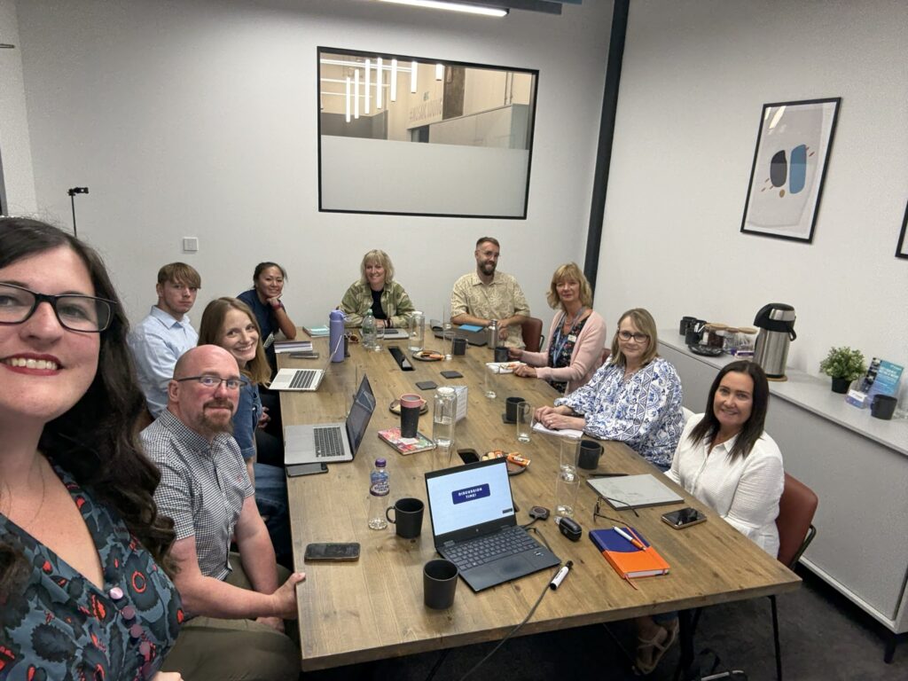 9 workshop attendees sat round a table at one of Arcanum Academy's workshops.