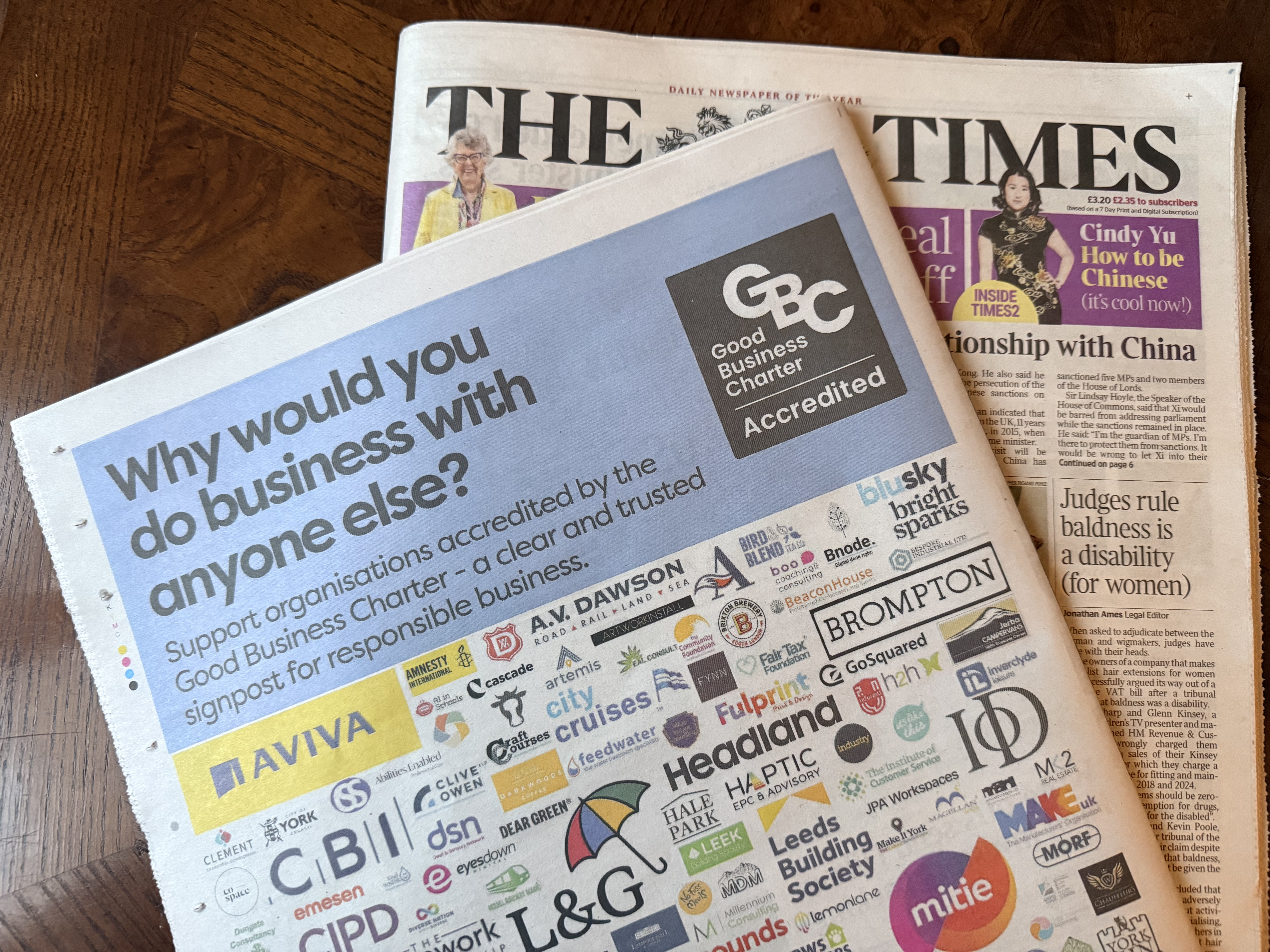 The Times Newspaper laid on a table with the Arcanum logo in it.
