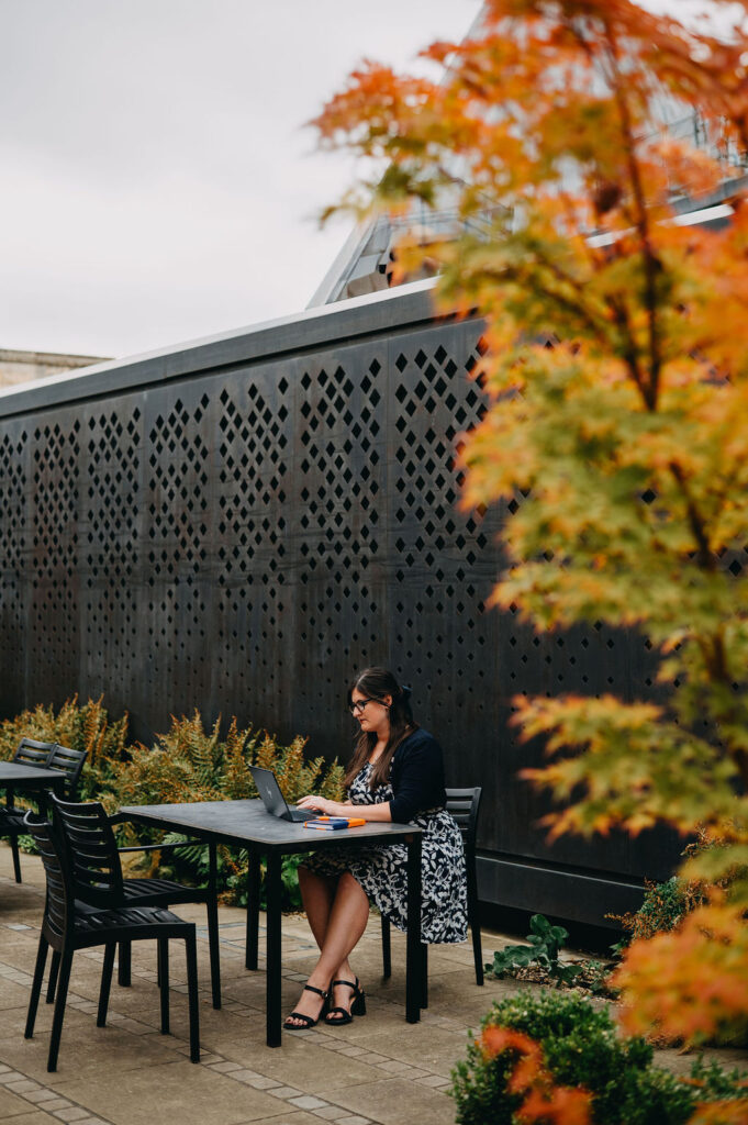 A copywriter sat at a table on her laptop near Lincoln cathedral.