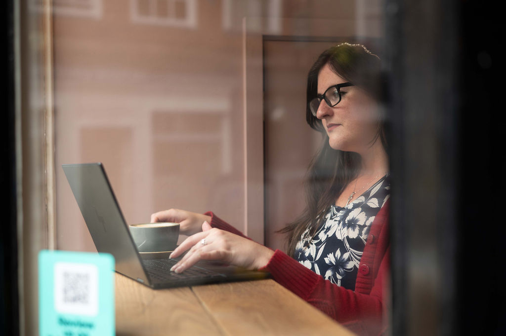 A copywriter sat at a desk on her laptop.