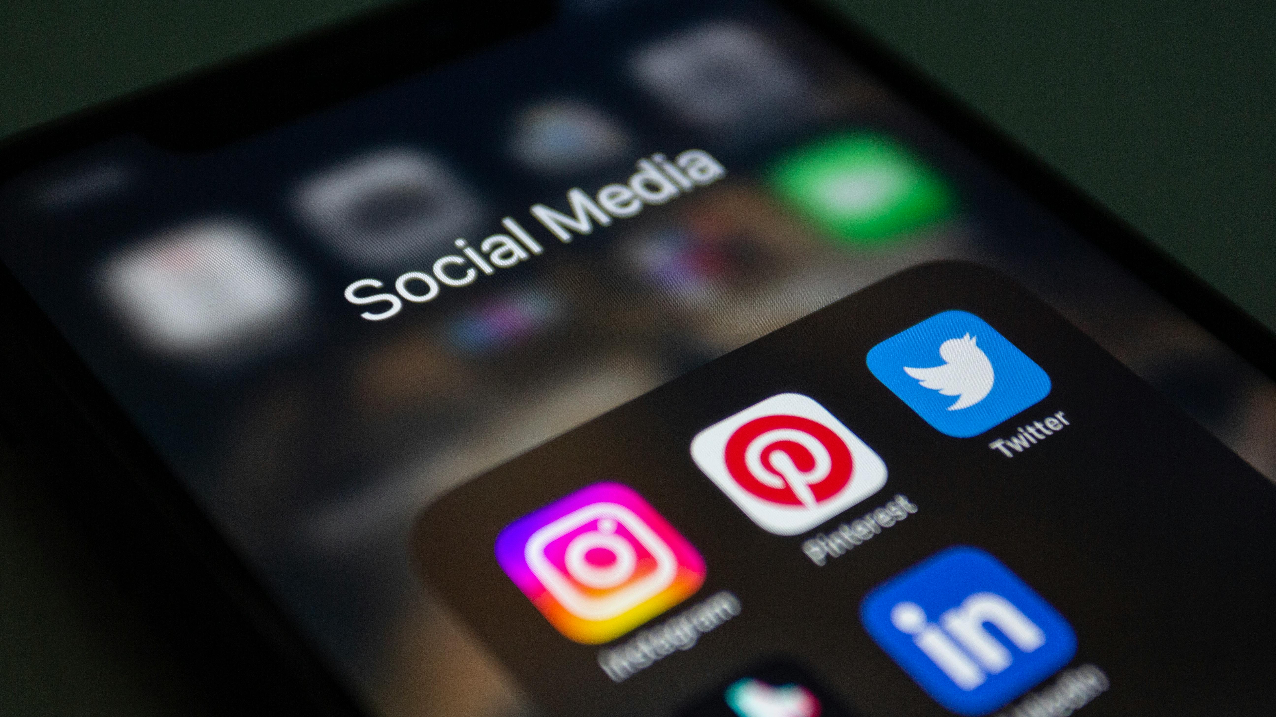 A close up image of a phone with social media icons on the screen.