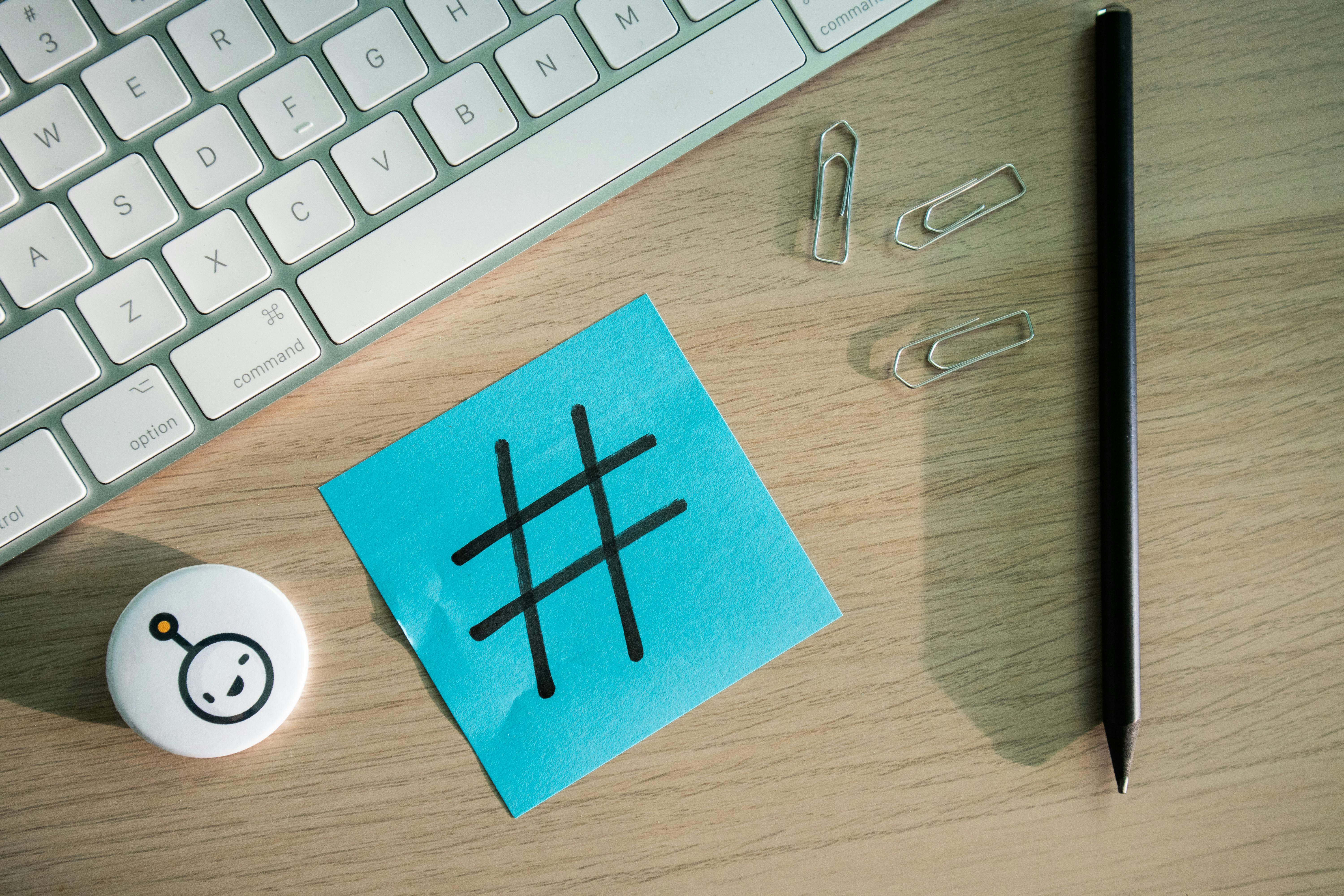 A post-it note on a desk with a hashtag symbol written on it.